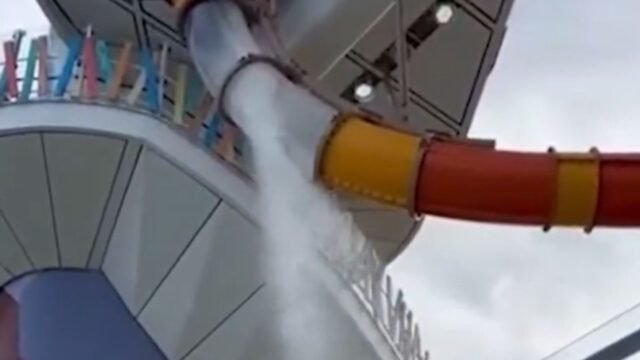 El pasajero de crucero se fue 'abierto' como el tobogán acuático en el icono de los mares que se rompe que envían agua vertiendo sobre cubierta
